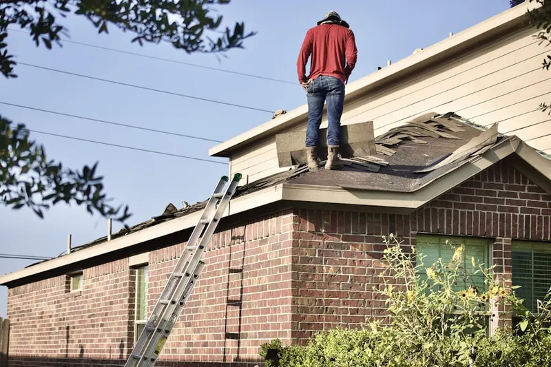 Professional roofer working on a residential roof in Juanamaria